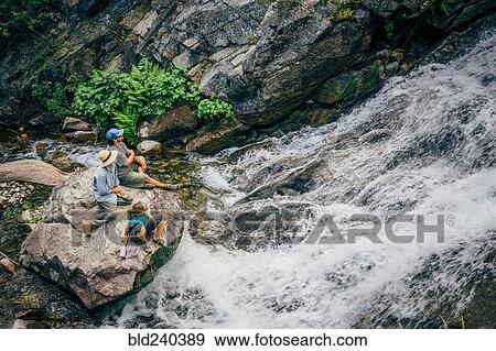 Caucasian people sitting on rock watching river rapids View Large Photo Image Stock Photo - Caucasian people sitting on rock watching river rapids. Fotosearch
