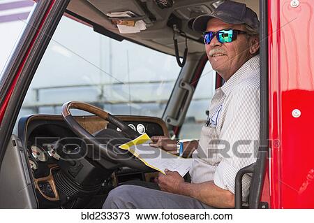 Caucasian semi-truck driver holding paperwork View Large Photo Image Stock Image - Caucasian semi-truck driver holding paperwork. Fotosearch