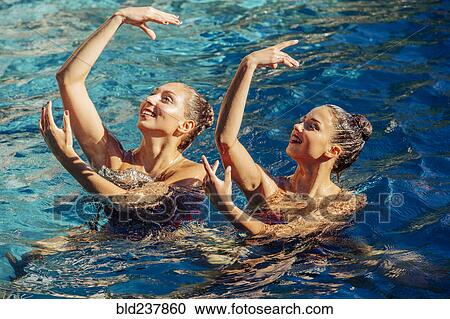 Caucasian synchronized swimmers with arms raised View Large Photo Image Stock Image - Caucasian synchronized swimmers with arms raised. Fotosearch