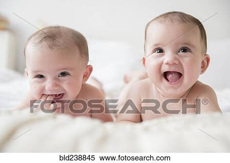 Caucasian twin baby girls smiling on bed View Large Photo Image Stock Photography - Caucasian twin baby girls smiling on bed. Fotosearch