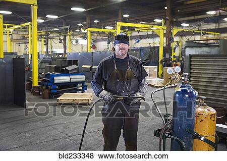Caucasian welder posing with blowtorch in factory View Large Photo Image Stock Photo - Caucasian welder posing with blowtorch in factory. Fotosearch