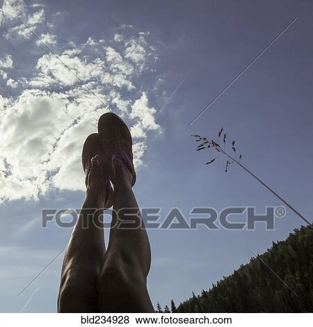Caucasian with legs raised to blue sky View Large Photo Image Stock Photo - Caucasian with legs raised to blue sky. Fotosearch