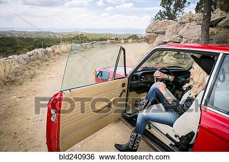 Stock Photograph - Caucasian woman admiring scenic view from car. Fotosearch