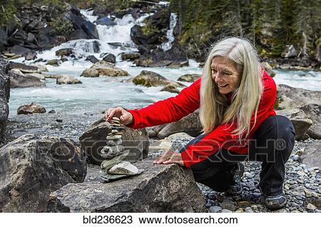 Caucasian woman balancing stack of rocks View Large Photo Image Stock Image - Caucasian woman balancing stack of rocks. Fotosearch