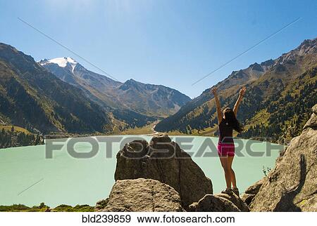 Caucasian woman celebrating on rocks near mountain lake View Large Photo Image Stock Photo - Caucasian woman celebrating on rocks near mountain lake. Fotosearch