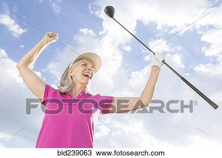 Caucasian woman celebrating with golf club View Large Photo Image Stock Image - Caucasian woman celebrating with golf club. Fotosearch