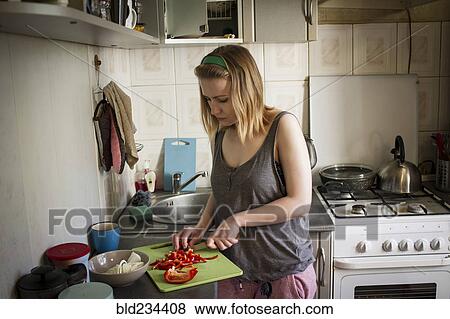 Caucasian woman cutting red peppers in kitchen View Large Photo Image Stock Photo - Caucasian woman cutting red peppers in kitchen. Fotosearch