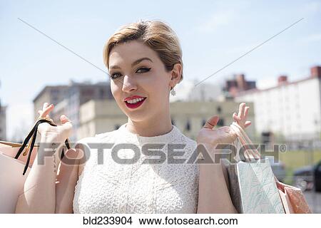 Picture - Caucasian woman displaying shopping bags. Fotosearch