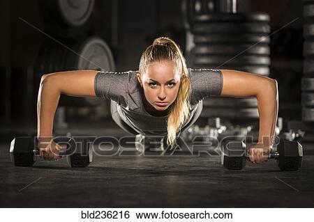 Caucasian woman doing push-up using dumbbells in gymnasium View Large Photo Image Stock Photograph - Caucasian woman doing push-up using dumbbells in gymnasium. Fotosearch