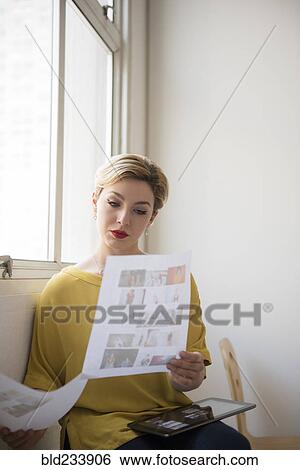 Stock Photograph - Caucasian woman examining paperwork. Fotosearch