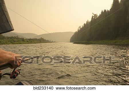 Stock Image - Caucasian woman fishing in river. Fotosearch
