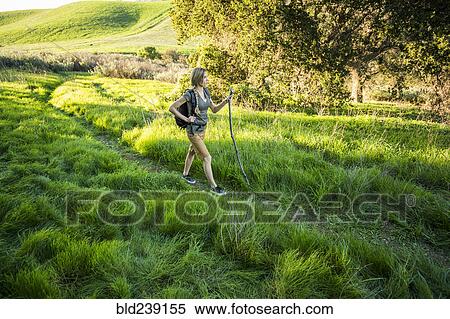 Stock Photography - Caucasian woman hiking on hill. Fotosearch