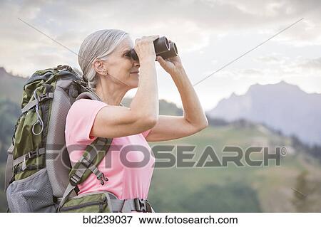 Caucasian woman hiking on mountain using binoculars View Large Photo Image Stock Photo - Caucasian woman hiking on mountain using binoculars. Fotosearch