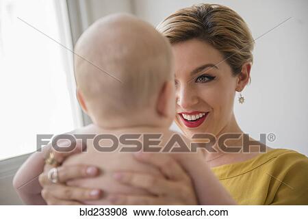 Stock Photo - Caucasian woman holding baby boy. Fotosearch