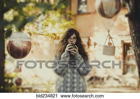 Stock Image - Caucasian woman holding ball near face. Fotosearch