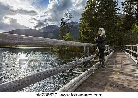 Caucasian woman holding binoculars at mountain lake View Large Photo Image Stock Photo - Caucasian woman holding binoculars at mountain lake. Fotosearch