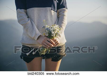 Stock Photography - Caucasian woman holding bouquet of wildflowers. Fotosearch