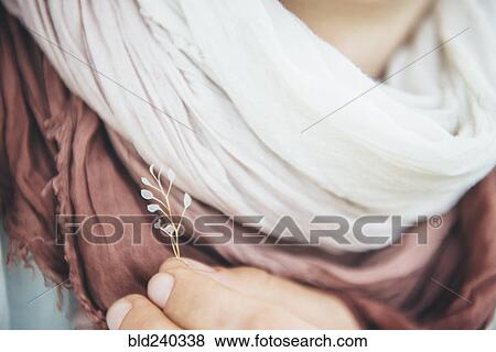 Caucasian woman holding delicate leaf near scarf View Large Photo Image Stock Photo - Caucasian woman holding delicate leaf near scarf. Fotosearch
