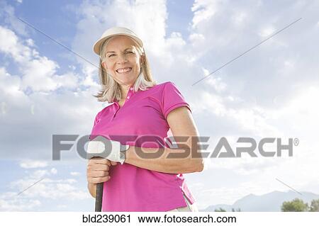Stock Image - Caucasian woman holding golf club. Fotosearch