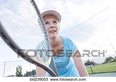 Stock Image - Caucasian woman holding tennis racket. Fotosearch