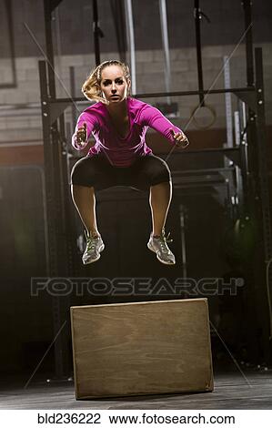 Caucasian woman jumping on box in gymnasium View Large Photo Image Stock Image - Caucasian woman jumping on box in gymnasium. Fotosearch