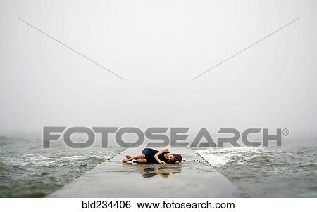 Caucasian woman laying on dock in ocean waves View Large Photo Image Stock Photograph - Caucasian woman laying on dock in ocean waves. Fotosearch