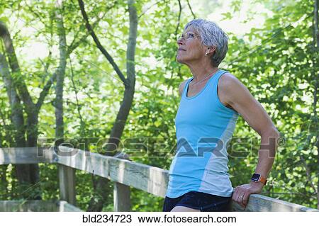 Caucasian woman leaning on wooden fence looking up View Large Photo Image Stock Image - Caucasian woman leaning on wooden fence looking up. Fotosearch