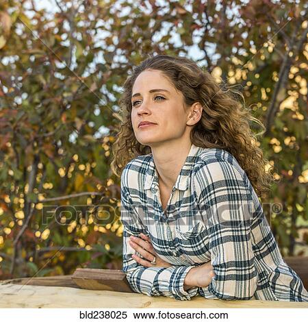 Stock Photography - Caucasian woman leaning on wooden fence. Fotosearch