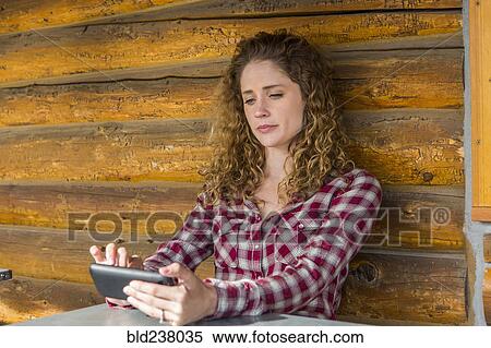 Caucasian woman leaning on wooden wall texting on cell phone View Large Photo Image Stock Photography - Caucasian woman leaning on wooden wall texting on cell phone. Fotosearch