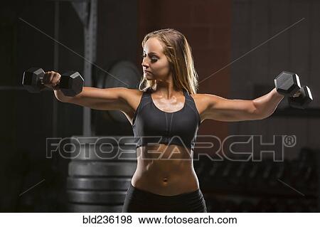 Caucasian woman lifting dumbbells in gymnasium View Large Photo Image Stock Photo - Caucasian woman lifting dumbbells in gymnasium. Fotosearch