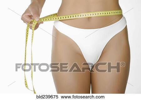Stock Photography - Caucasian woman measuring waist. Fotosearch