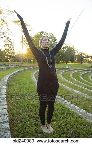 Caucasian woman meditating on grass in park View Large Photo Image Stock Photo - Caucasian woman meditating on grass in park. Fotosearch