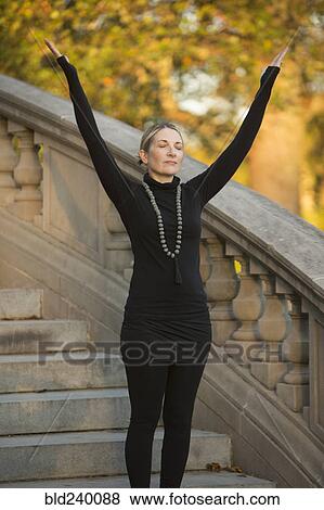 Caucasian woman meditating on staircase in park View Large Photo Image Stock Photo - Caucasian woman meditating on staircase in park. Fotosearch