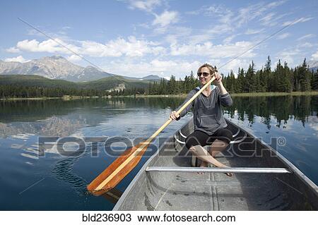 Stock Image - Caucasian woman paddling in kayak. Fotosearch