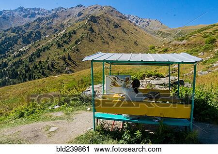 Stock Image - Caucasian woman painting mountain landscape. Fotosearch