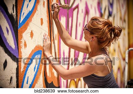 Caucasian woman painting mural on wall View Large Photo Image Stock Photo - Caucasian woman painting mural on wall. Fotosearch