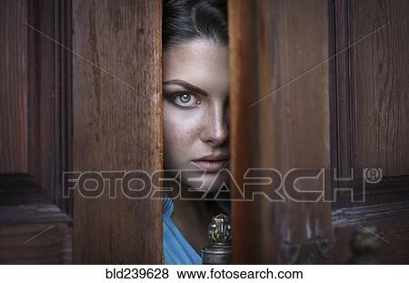 Caucasian woman peeking in doorway View Large Photo Image Stock Photo - Caucasian woman peeking in doorway. Fotosearch