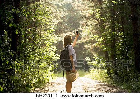 Caucasian woman photographing forest trees with cell phone View Large Photo Image Stock Image - Caucasian woman photographing forest trees with cell phone. Fotosearch