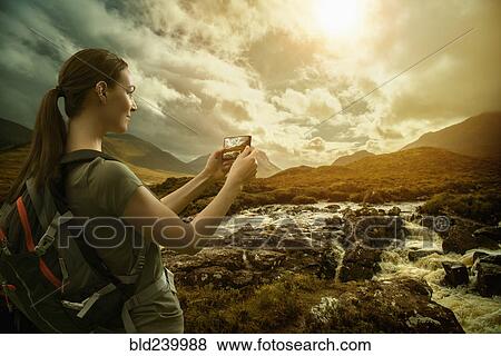 Caucasian woman photographing mountain river with cell phone View Large Photo Image Stock Photo - Caucasian woman photographing mountain river with cell phone. Fotosearch