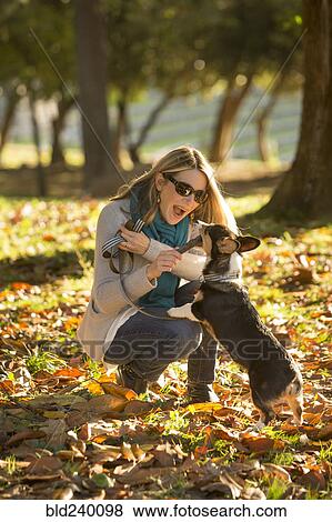Caucasian woman playing with dog in park View Large Photo Image Stock Photo - Caucasian woman playing with dog in park. Fotosearch