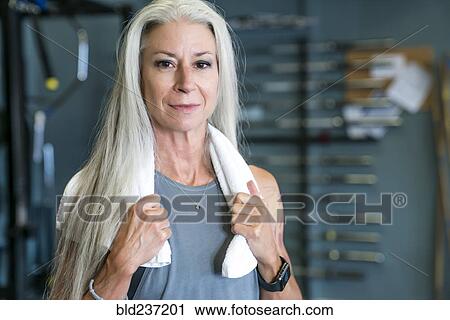 Stock Image - Caucasian woman posing in gymnasium wearing towel. Fotosearch