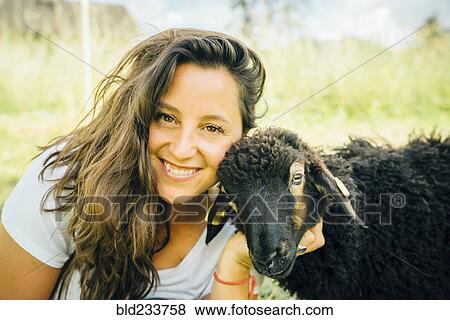 Stock Photo - Caucasian woman posing with sheep. Fotosearch