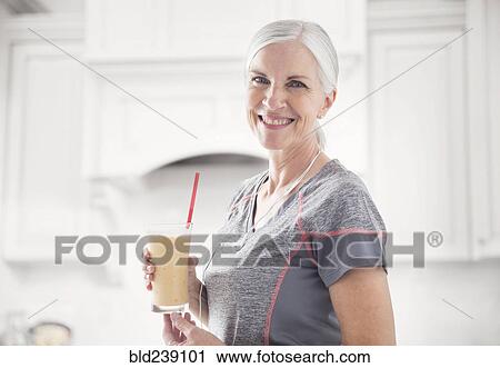 Stock Image - Caucasian woman posing with smoothie. Fotosearch