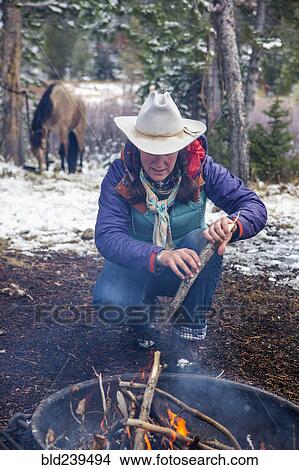 Caucasian woman putting wood in campfire View Large Photo Image Picture - Caucasian woman putting wood in campfire. Fotosearch