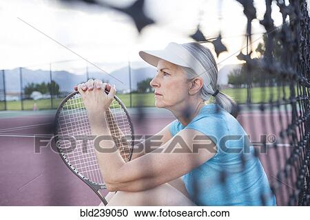 Caucasian woman resting and holding tennis racket View Large Photo Image Stock Image - Caucasian woman resting and holding tennis racket. Fotosearch