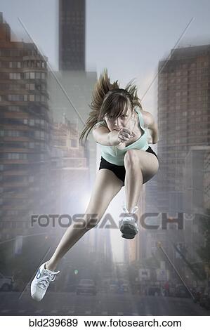 Caucasian woman running and jumping in city View Large Photo Image Stock Photo - Caucasian woman running and jumping in city. Fotosearch