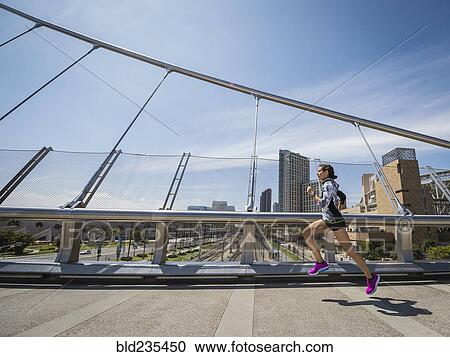 Caucasian woman running on bridge View Large Photo Image Stock Image - Caucasian woman running on bridge. Fotosearch