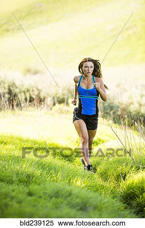 Stock Photography - Caucasian woman running on hill. Fotosearch