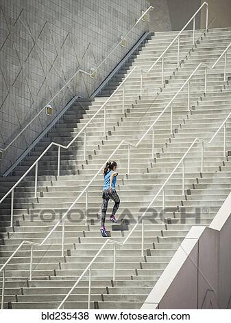 Stock Photo - Caucasian woman running on staircase. Fotosearch
