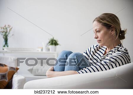 Caucasian woman sitting in armchair holding legs View Large Photo Image Stock Image - Caucasian woman sitting in armchair holding legs. Fotosearch